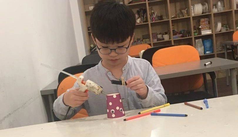 Student using a glue gun in an after-school STEM class