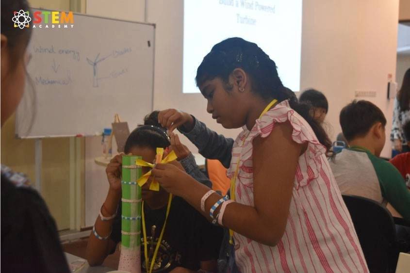 Children at a science experiment station during camp