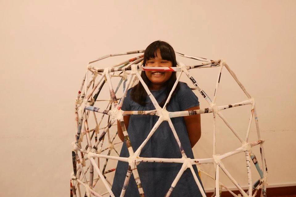 Child standing inside a geodesic dome built by students