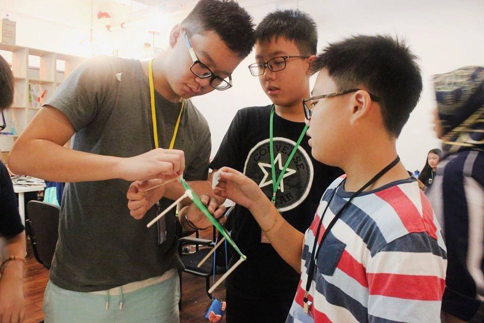 Students building a straw structure together